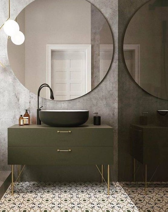 Tocador de baño negro con lavabo dorado y un espejo grande
