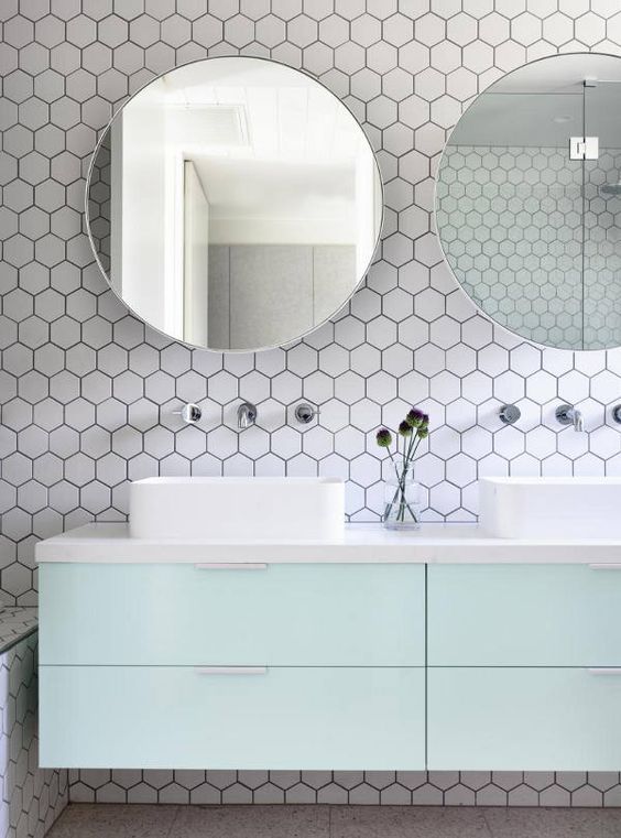 Baño en tonos blanco y mint con baldosas hexagonales en la pared