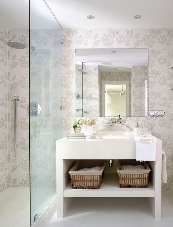 Baño con papel pintado en tonos claros incluso en la zona de ducha