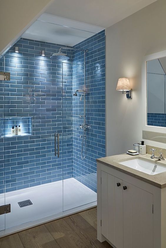 FIjo de ducha con plato blanco y azulejos azules
