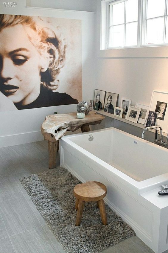 Baño con fotos junto a la bañera y cuadro grande