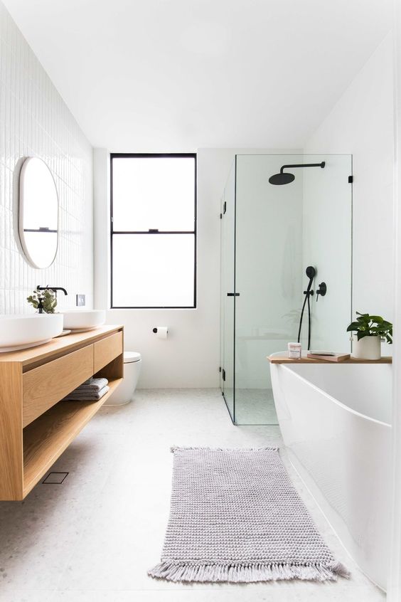 Baño de estilo nórdico con bañera y mampara de ducha de estilo industrial Mampara de ducha industrial en baño nórdico con bañera y encimera suspendida