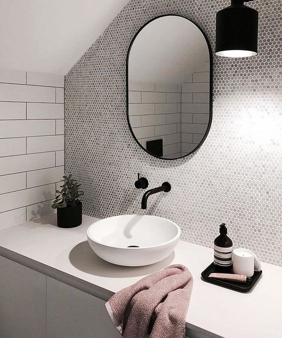 Tocador de baño de estilo industrial con grifos en negro y espejo ovalado